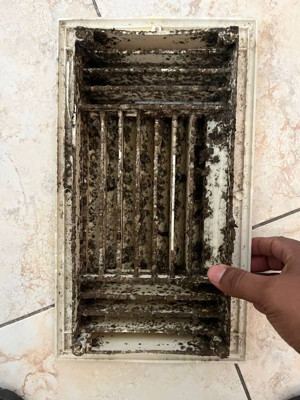 Heavily contaminated duct register with years of dust buildup before cleaning