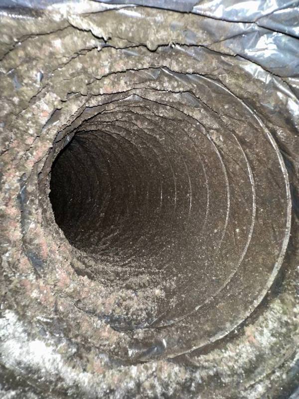 Air duct interior clogged with years of dust debris and allergens Houston home